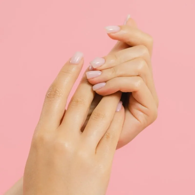 Mains aux ongles nude parfaitement manucurés, salon de Roanne